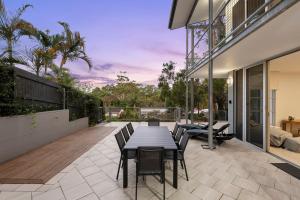 a patio with a table and chairs on a deck at The Hideaway Currumbin in Gold Coast