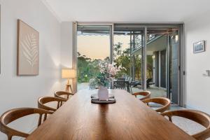 a dining room with a wooden table and chairs at The Hideaway Currumbin in Gold Coast