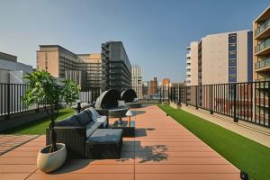 a balcony with couches and chairs on a building at Moat Inside Tenjin in Fukuoka