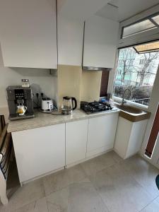 a kitchen with white cabinets and a stove top oven at Zen 2 Bedroom Apartment with Terrace in Zalău