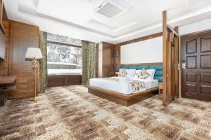 a bedroom with a bed and a large window at Badar Resorts & Spa by Stay Pattern Riverside in Sonāmarg