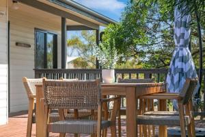 a wooden table and chairs on a deck at Viaggio Sul Mare in Baudin Beach +7 photos