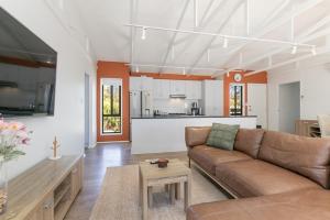 a living room with a couch and a kitchen at Viaggio Sul Mare in Baudin Beach