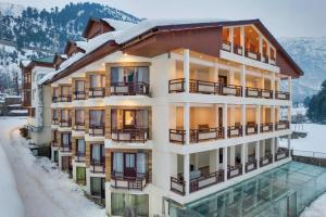 a building with a pool in the snow at Badar Resorts & Spa by Stay Pattern Riverside in Sonāmarg