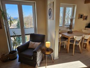 a living room with a chair and a table at Küstenglück 3 Modernes Maisonette-Apartment mit Meerblick & Kickerspaß - 200m zum Strand & Bäcker in Dahme
