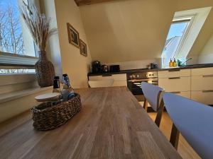 a kitchen with a wooden table with a bottle of wine at Küstenglück 3 Modernes Maisonette-Apartment mit Meerblick & Kickerspaß - 200m zum Strand & Bäcker in Dahme