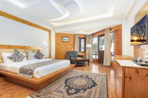 a bedroom with a bed and a living room at Badar Resorts & Spa by Stay Pattern Riverside in Sonāmarg