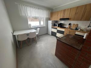 a small kitchen with a table and a white refrigerator at Emmaste Apartment in Emmaste