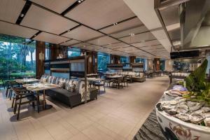 a restaurant with tables and chairs and windows at Le Méridien Xiamen in Xiamen