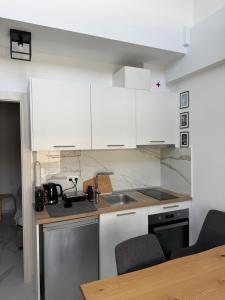 a kitchen with white cabinets and a wooden table at Anastasia B in Ofrínion