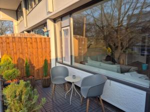 a patio with two chairs and a couch through a window at Kintsugi in Alphen aan den Rijn