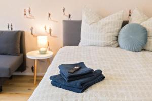 a bed with towels and a remote control on it at Stadtoase Chemnitz in Chemnitz