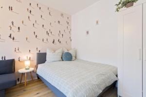 a bedroom with a bed and a wall with people on it at Stadtoase Chemnitz in Chemnitz