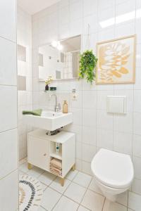 a white bathroom with a toilet and a sink at Stadtoase Chemnitz in Chemnitz