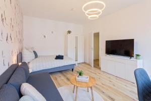 a living room with a couch and a flat screen tv at Stadtoase Chemnitz in Chemnitz