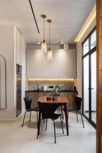a kitchen with a wooden table and chairs at Blueloft 52 I Tashkent City Center in Tashkent