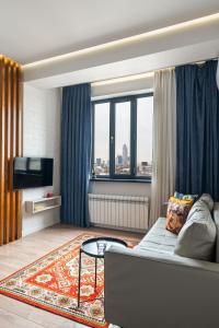 a living room with a couch and a tv at Blueloft 52 I Tashkent City Center in Tashkent