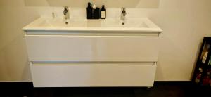 a white bathroom sink with two faucets on it at La Petite Auberge de Graux in Mettet +1 photo