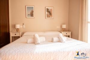 a bedroom with a bed with white sheets and pillows at El Velero Piscina top y tranquilidad a 450m playa in San José