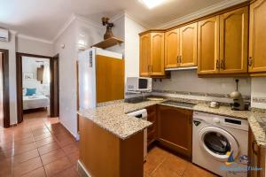 a kitchen with wooden cabinets and a washer and dryer at El Velero Piscina top y tranquilidad a 450m playa in San José +28 photos