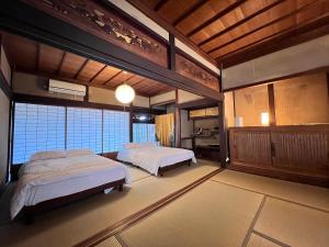 a bedroom with two beds in a room at 瀬戸内海を望む庭付き古民家サウナ宿 一棟貸切 in Takamatsu