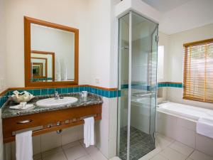 
a bathroom with a shower, sink, and tub at Green Island Resort in Green Island
