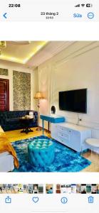 a living room with a tv and a blue ottoman at Luxury hotel t&l in Cẩm Phả