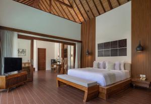 a bedroom with a bed and a flat screen tv at The Prime Seminyak by Kanaya Hospitality in Seminyak