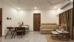 a living room with a couch and a table at CozyKey Kalina in Mumbai