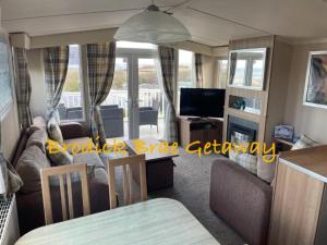 a living room with a couch and a television at Brodick Brae Getaway in Dunure