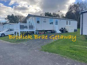 a white house with a car parked in front of it at Brodick Brae Getaway in Dunure