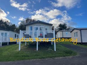 a sign in the grass in front of a house at Brodick Brae Getaway in Dunure +2 photos