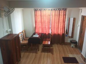 a room with a desk and two chairs and a window at Joyous Rooms in Cherrapunji