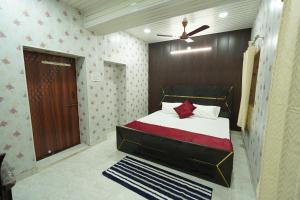 a bedroom with a bed and a ceiling fan at Shiv Kothi Home Stay in Varanasi