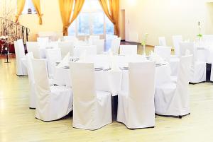 een kamer met witte tafels en witte stoelen bij Hotel Arkadia in Legnica