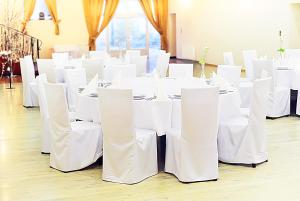 a room with white tables and white chairs at Hotel Arkadia in Legnica