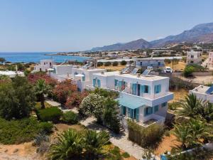an aerial view of a white house with the ocean at Makrigialos Apartments und Studios in Makry Gialos