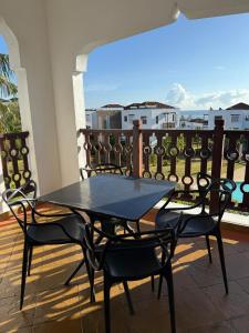 a table and chairs on a balcony with a view of the ocean at Sultan Palace Beach Resort - AMANI Apartment CB2-202 in Kikambala