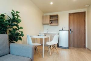 a kitchen with a couch and a table and a refrigerator at The View Chaengwattana 14 in Bangkok