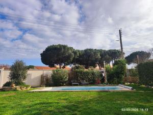 a backyard with a swimming pool in the grass at Chambres d'hôtes Sauvian in Sauvian