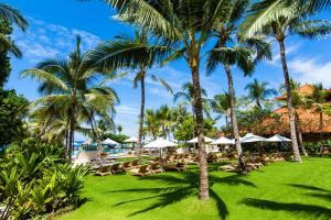 ośrodek z palmami, leżakami i basenem w obiekcie Ayodya Resort Bali w mieście Nusa Dua