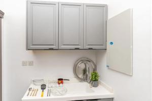 a kitchen with white cabinets and a sink at Jeddah Apartment in Jeddah +30 photos