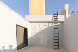 a ladder on the side of a building with a climbing wall at Jeddah Apartment in Jeddah