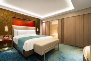 a bedroom with a large bed with a painting on the wall at China Hotel Guangzhou in Guangzhou
