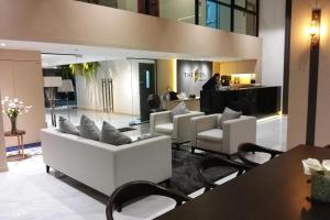 a living room with white couches and a table at The View Chaengwattana 14 in Bangkok
