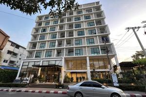 a car parked in front of a large building at The View Chaengwattana 14 in Bangkok