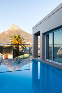 a house with a swimming pool with a mountain in the background at Villa on Slopes of Geneva Drive in Cape Town