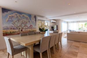 a dining room with a wooden table and chairs at Villa on Slopes of Geneva Drive in Cape Town
