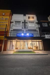 a building with a blue sign on the front of it at Phuket gateway inn in Kathu