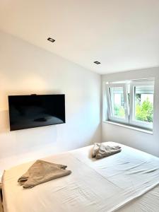 a bedroom with a bed with a flat screen tv on the wall at Artistik in Vodice
